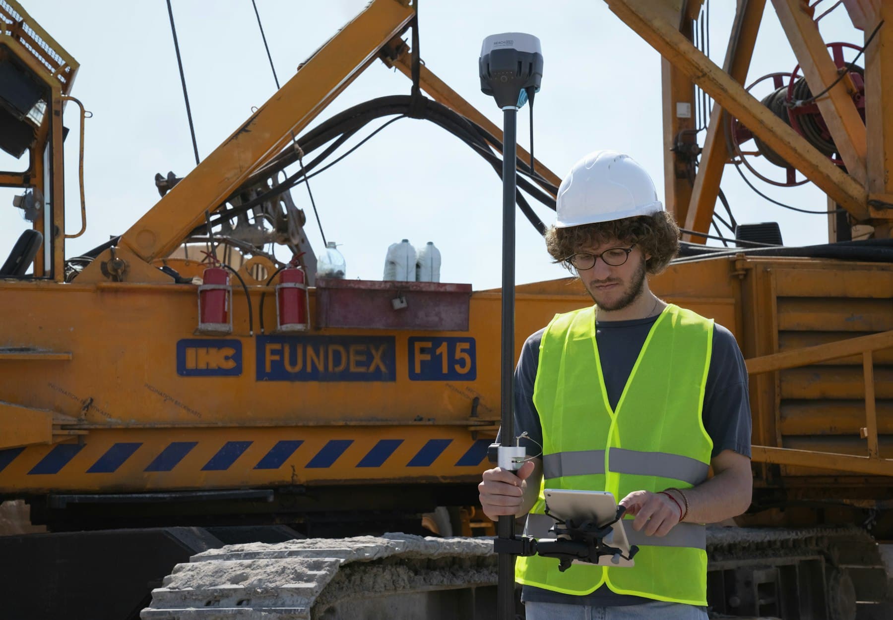 A land surveyor setting up equipment on a construction site